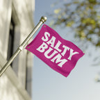 Pink flag with 'Salty Bum' text on a pole against a blurred background