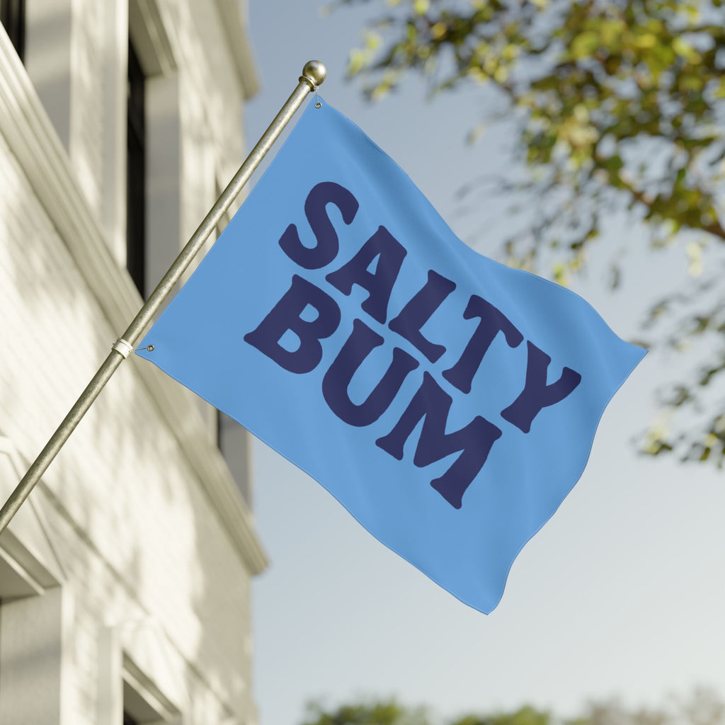 Blue flag with 'Salty Bum' text on a building exterior