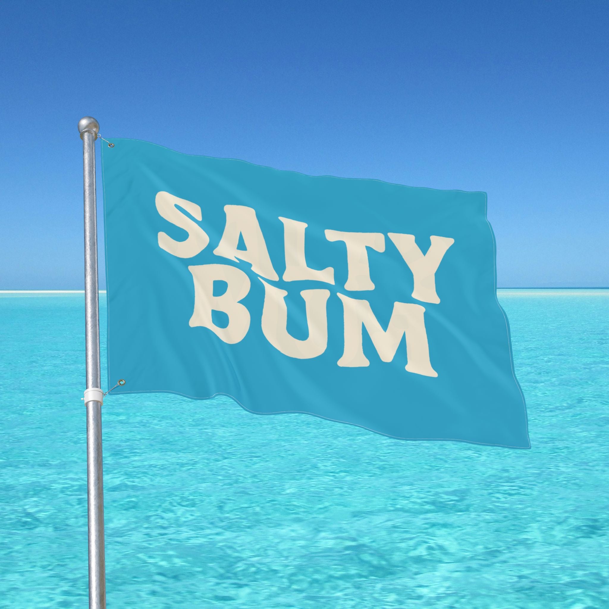 Flag with 'Salty Bum' text waving in front of a clear blue sky and ocean.