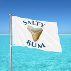 Flag with 'Salty Bum' text and a shark tooth graphic against a clear blue sky and ocean.