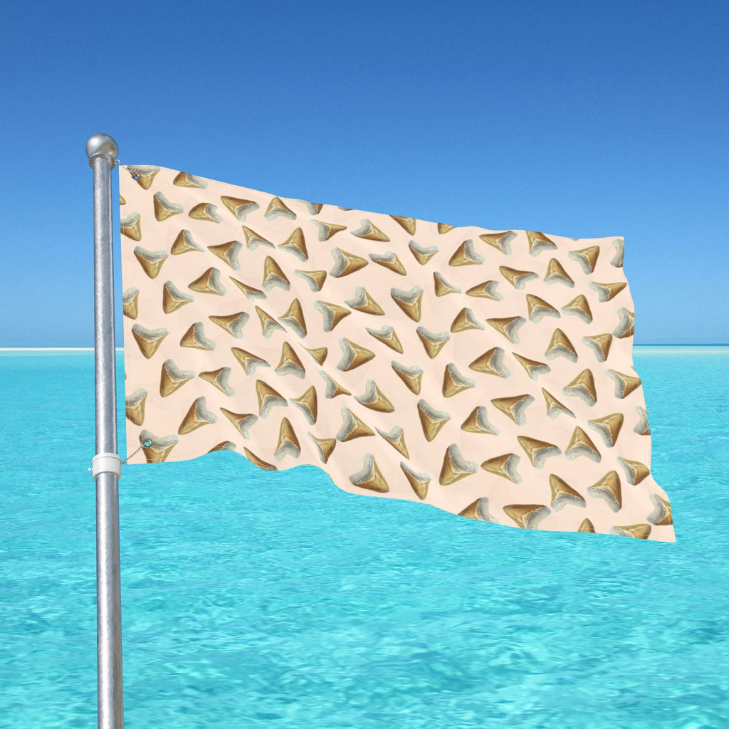 Flag with shark tooth pattern against a blue sky and ocean background