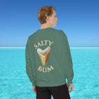 Person wearing a green sweatshirt with 'Salty Bum' text and ice cream cone graphic, standing in front of a blue ocean.