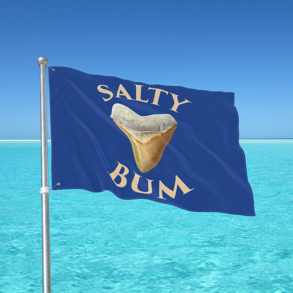 Flag with 'Salty Bum' text and a shark tooth graphic against a blue sky and ocean background.
