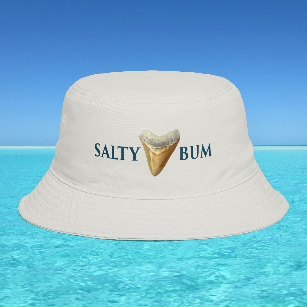 Beige bucket hat with 'Salty Bum' text and shark tooth graphic on a blue water and sky background