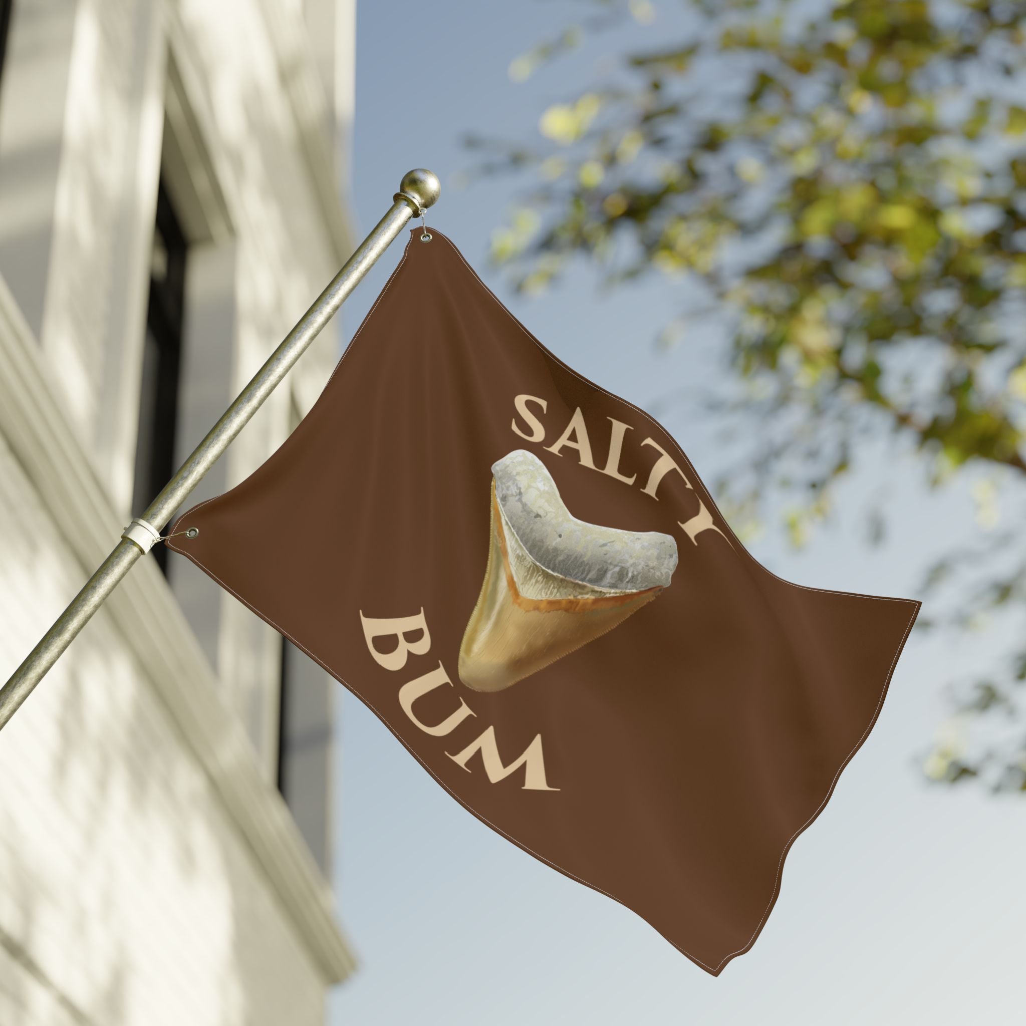 Flag with 'Salty Bum' logo on a pole against a clear sky