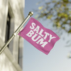 Pink flag with 'Salty Bum' text on a pole against a blurred background