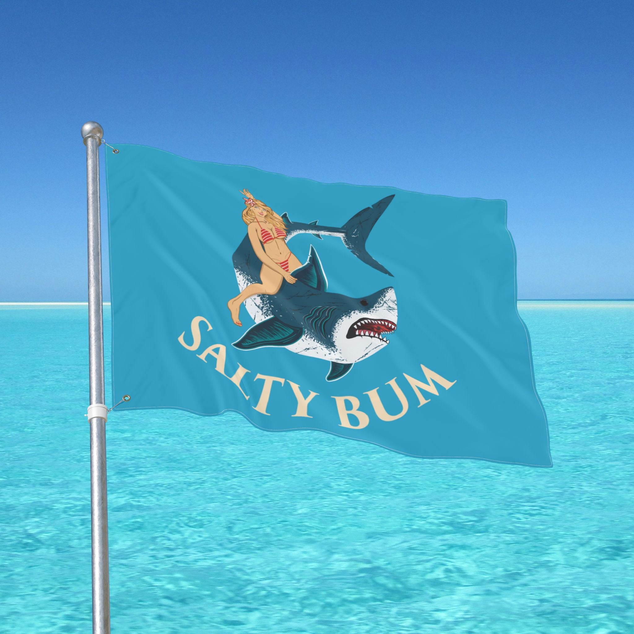 Flag with a shark and bikini-clad figure design against a clear blue sky.