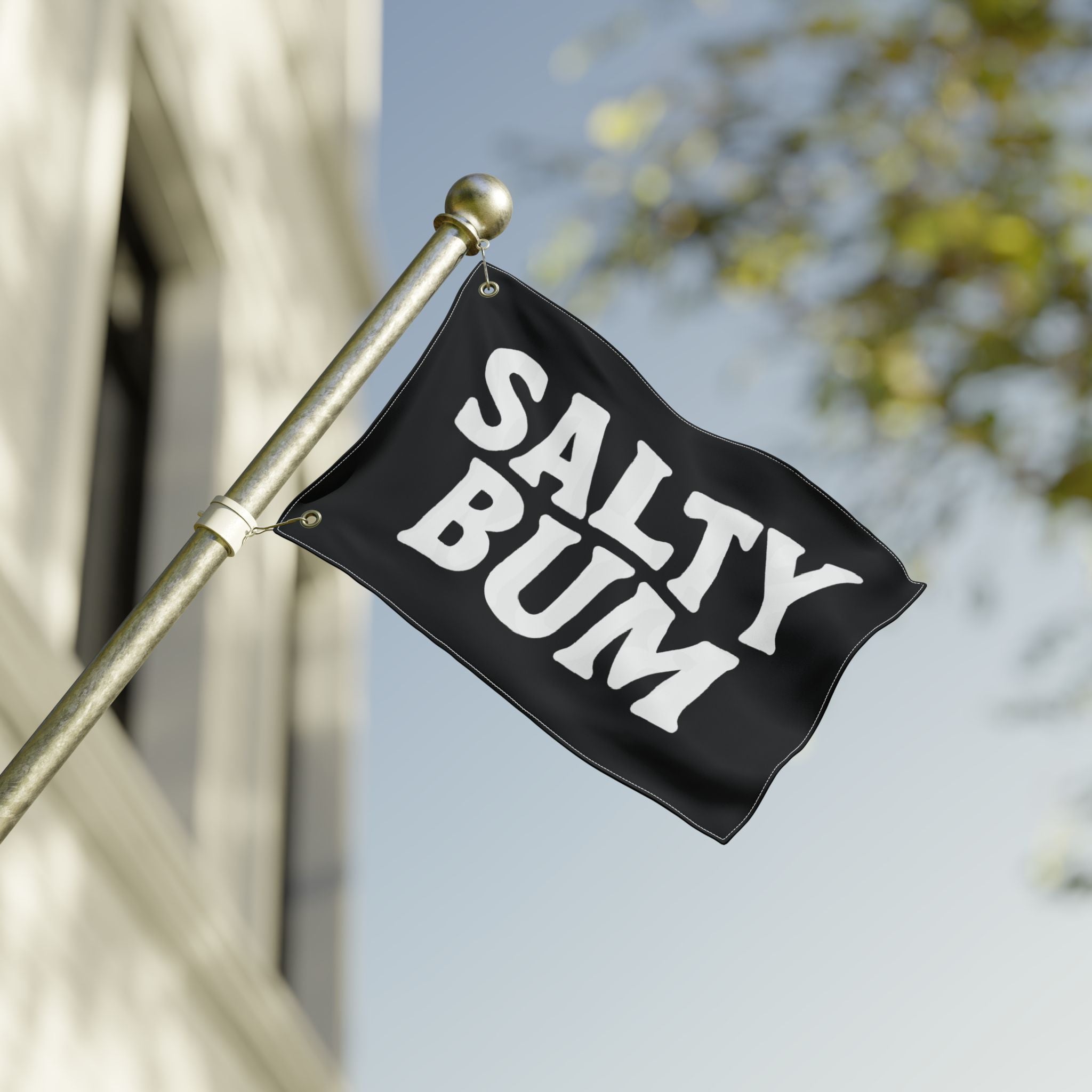 Black flag with 'Salty Bum' text waving on a pole against a blurred background