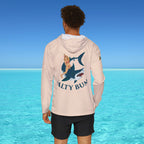 Person wearing a hoodie with a shark and mermaid design in front of clear blue water.