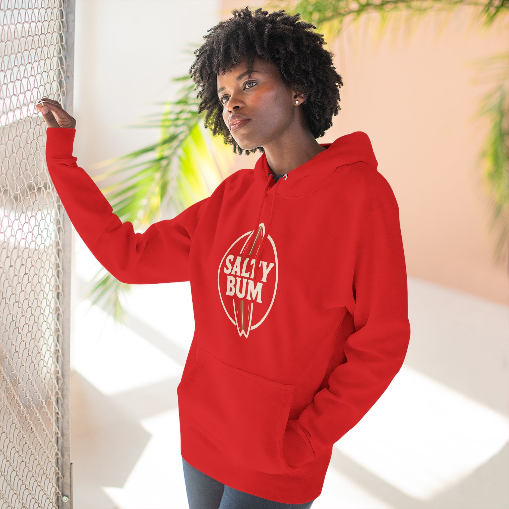 Person wearing a red hoodie with 'Salty Bum' logo, standing indoors with plants in the background