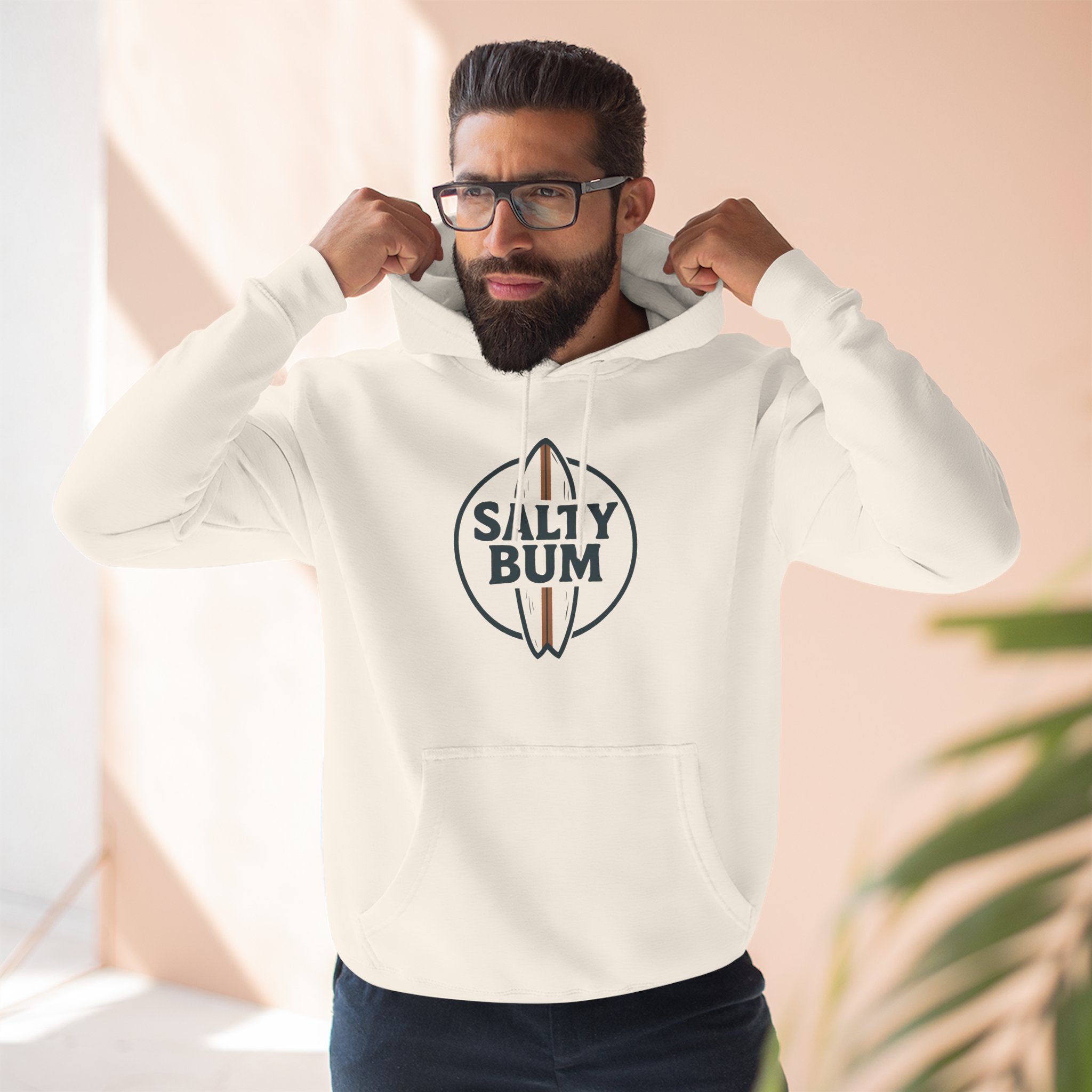 Man wearing a white hoodie with 'Salty Bum' logo indoors