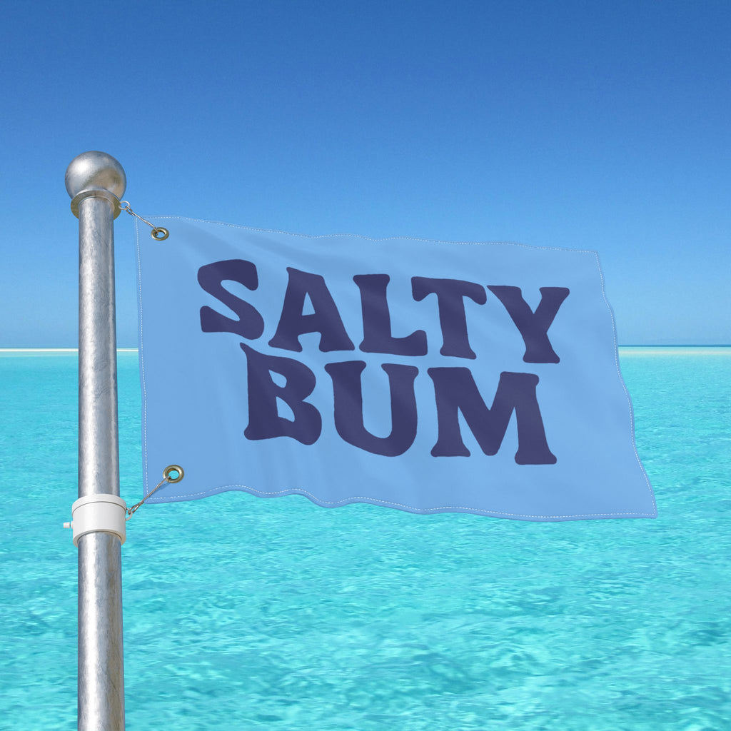 Flag with 'Salty Bum' text against a clear blue sky and ocean background