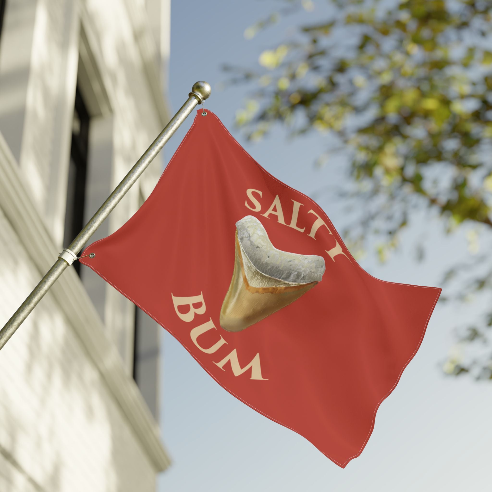 Red flag with 'Salt Bum' logo featuring a ice cream cone on a building facade.