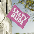 Pink flag with 'Salty Bum' text on a building facade
