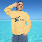 Person wearing a yellow sweatshirt with a shark graphic and text, standing in front of a blue ocean.