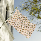 Decorative flag with geometric pattern on a flagpole against a blue sky.