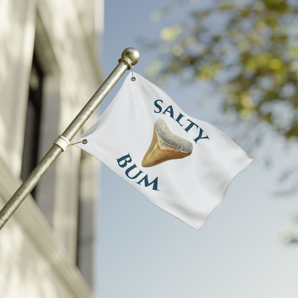 Flag with 'Salty Bum' text and a sand dollar graphic on a blurred background