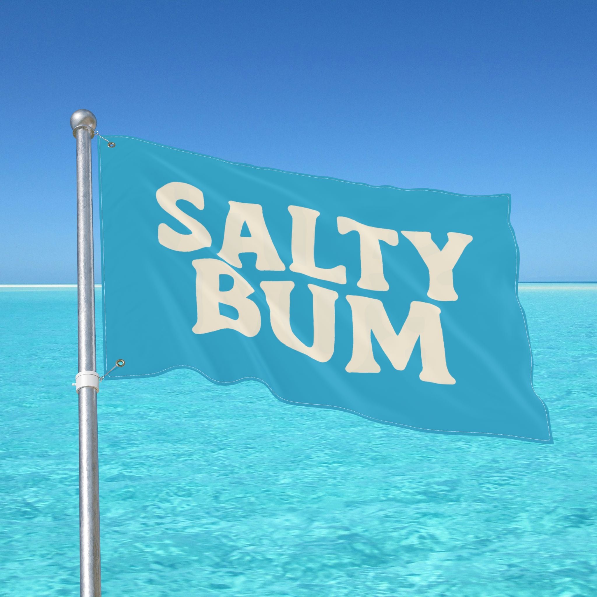 Flag with 'Salty Bum' text waving in front of a clear blue sky and ocean.
