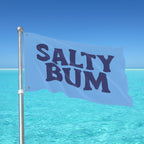 Flag with 'Salty Bum' text against a clear blue sky and ocean.