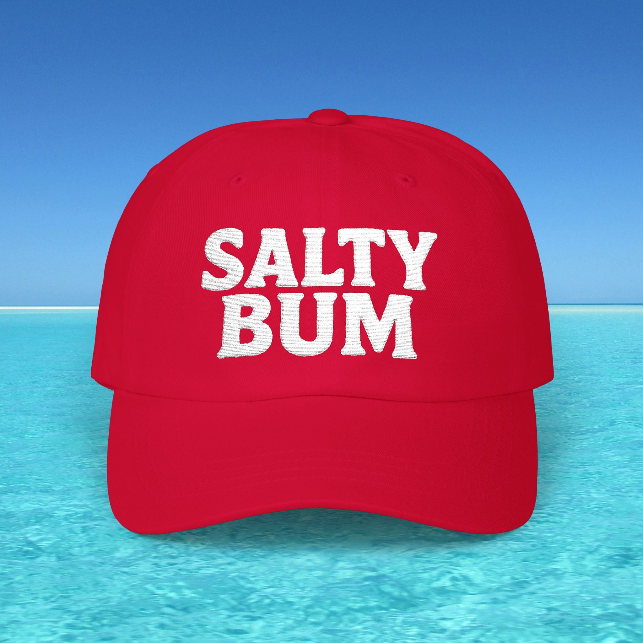 Red cap with 'Salty Bum' text on a beach background