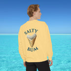 Person wearing a yellow sweatshirt with 'Salty Bum' text and ice cream graphic, standing in front of a blue ocean.