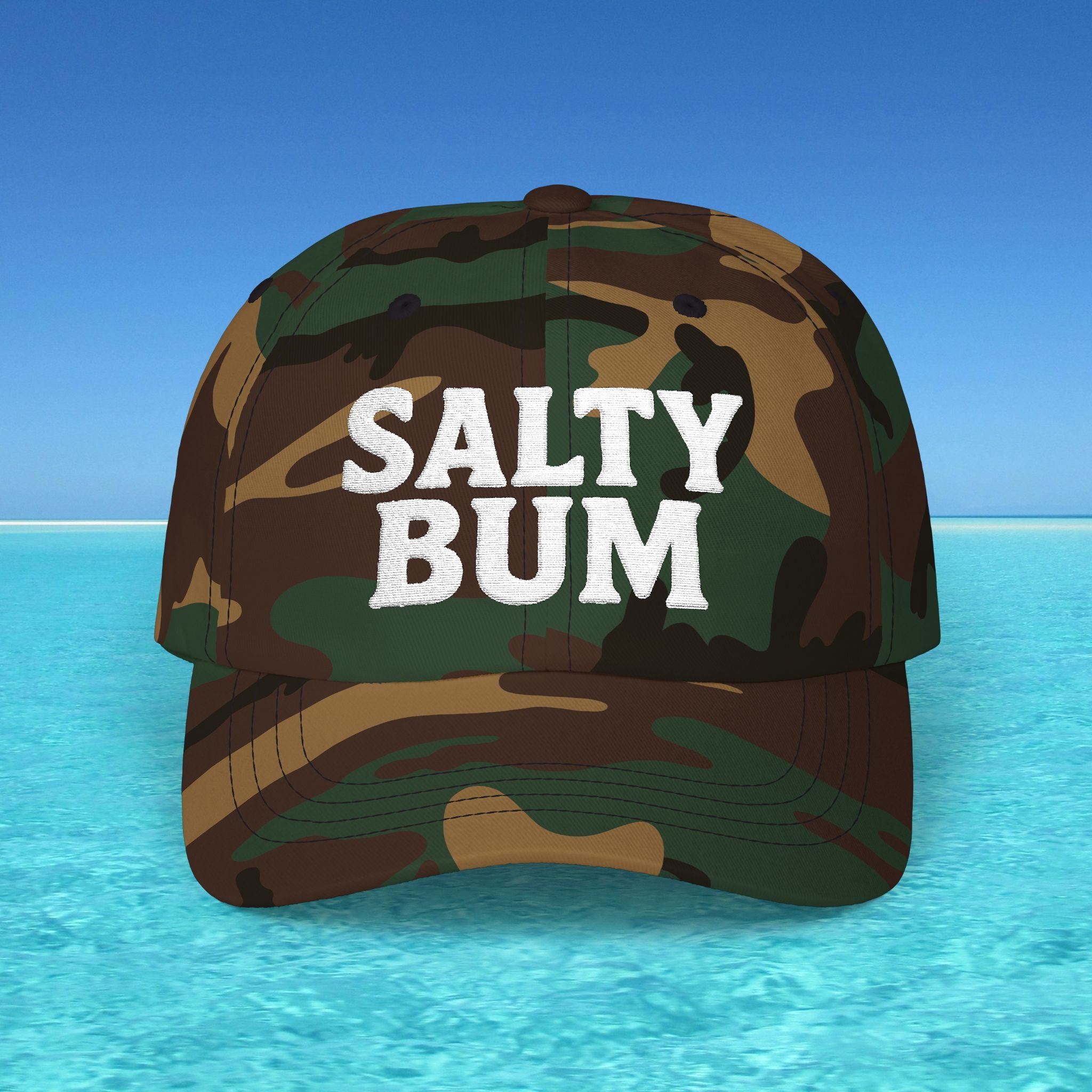 Camouflage cap with 'Salty Bum' text on a beach background