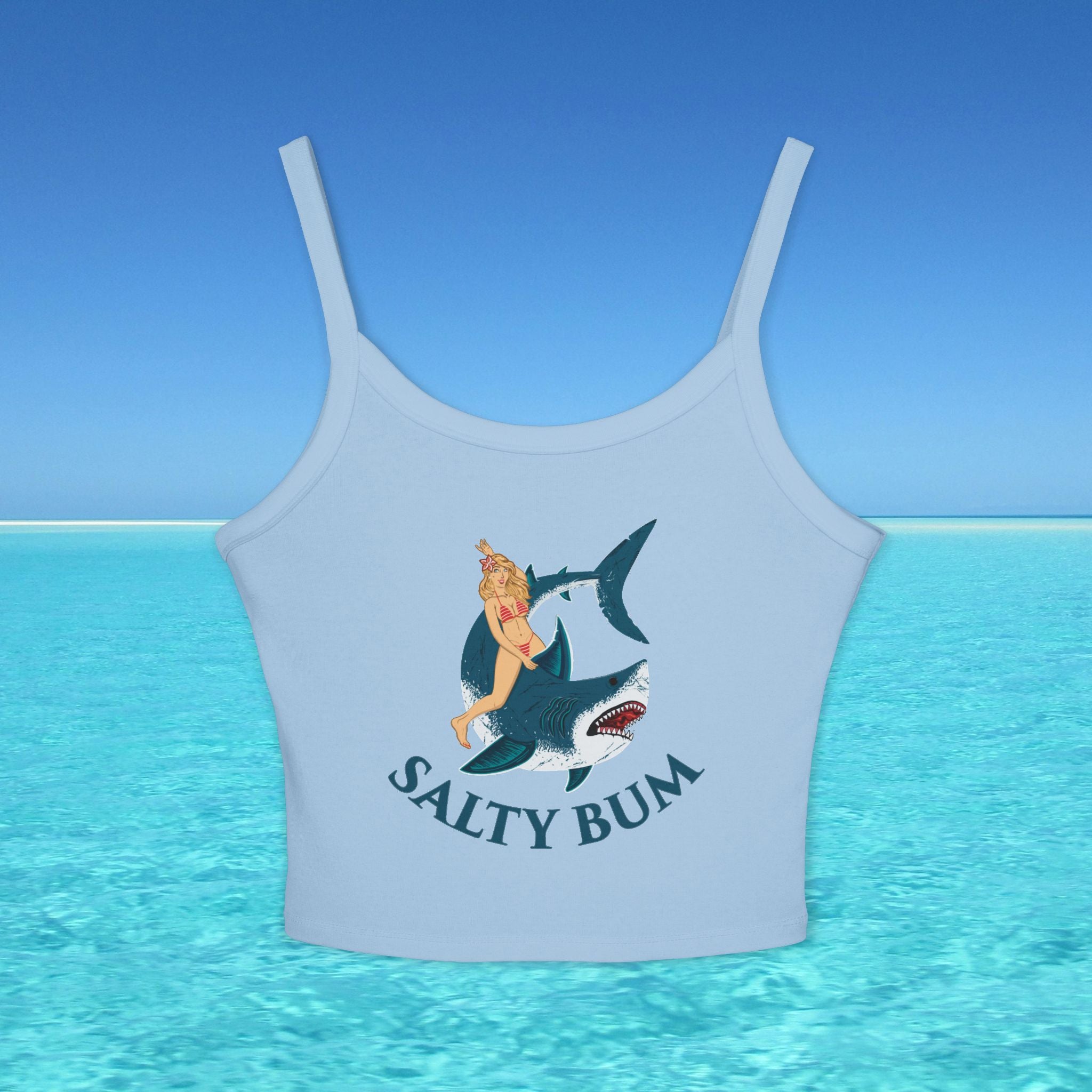 Light blue tank top with a graphic of a woman on a shark and 'Salty Bum' text, set against a blue water and sky background.