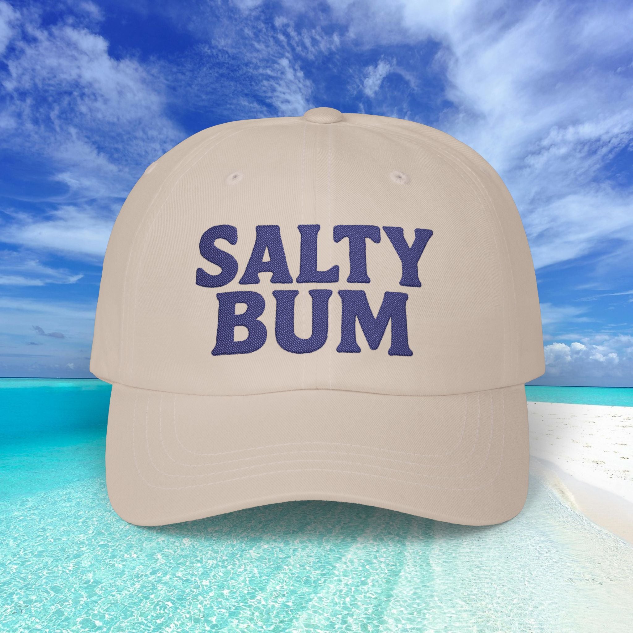 Beige cap with 'Salty Bum' text against a beach background